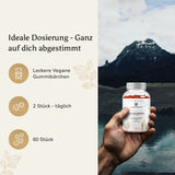 Mann trinkt Tee in der Natur mit Text über die Wirkung der Ashwagandha Gummies auf Balance & Wohlbefinden